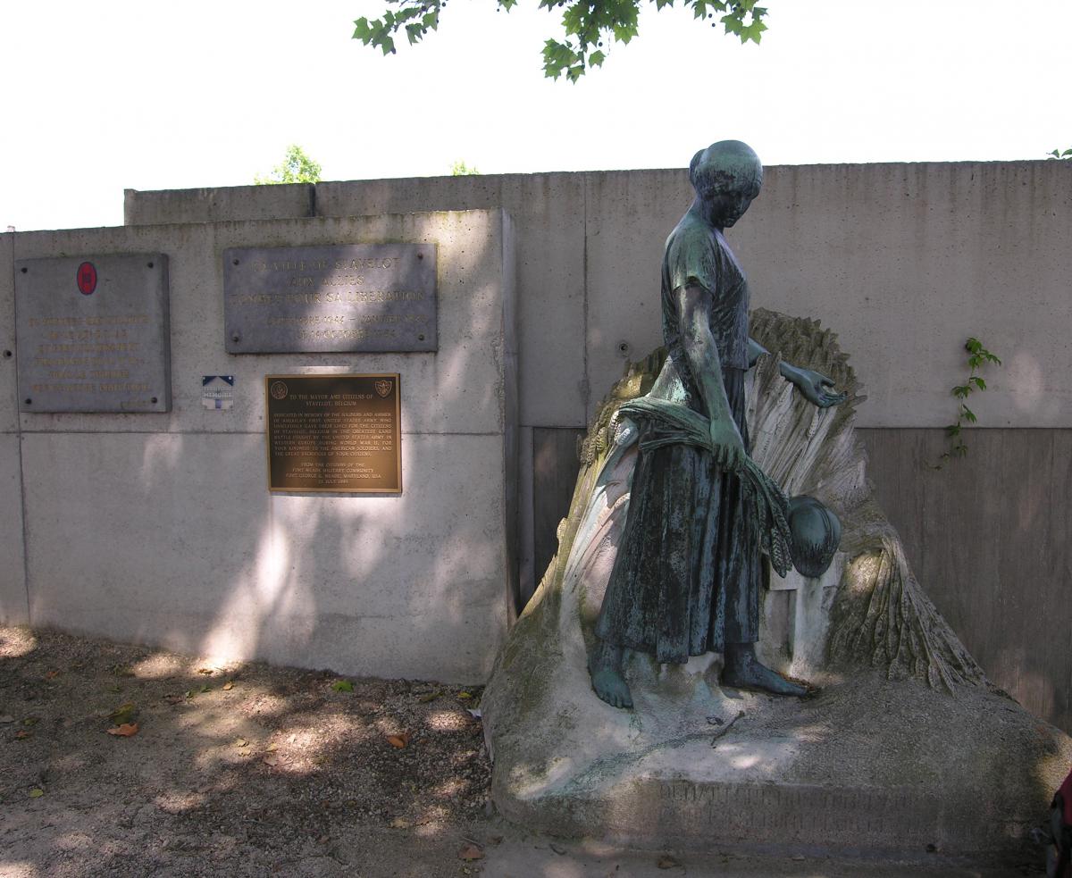 Hommage et dépôt de fleurs au Monument aux Morts de Stavelot. Statue de dame en bronze qui découvre dans un champs le casque d’un soldat mort au combat.
